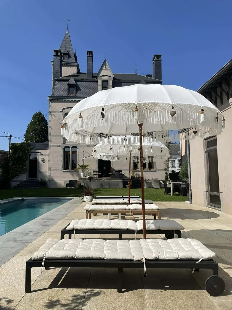 White fringed parasols and loungers by the pool of Villa O